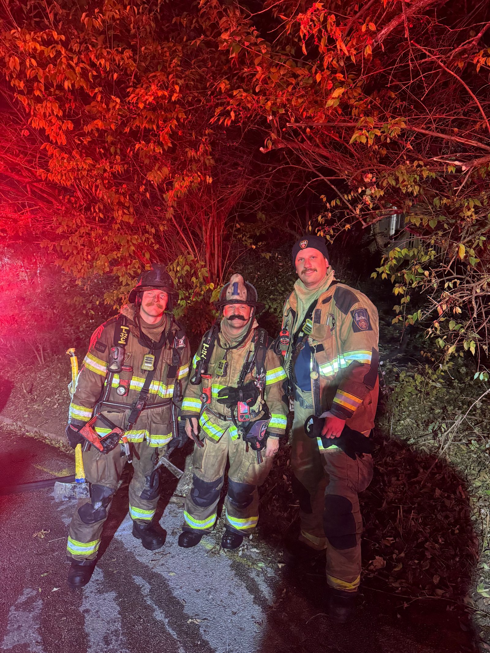 Martin Striefler with two fellow firefighters in full turnout gear at a nighttime structure fire scene