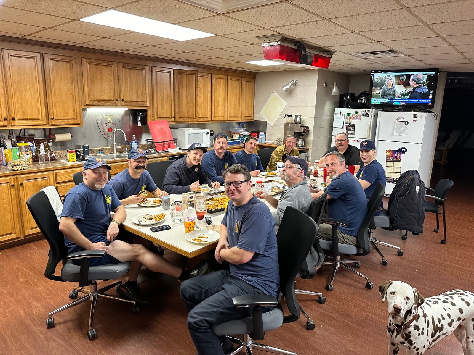 Firefighters gathered around the kitchen table at the station sharing a meal together